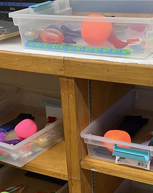 Boxes of educational toys in classroom cabinet