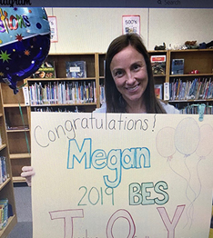 Teacher of the Year holding a Congratulations poster